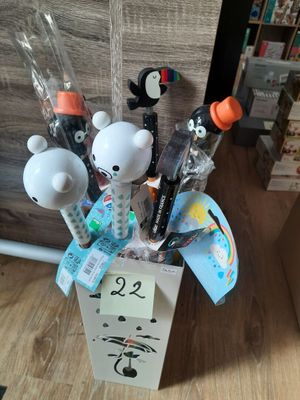 une boîte contenant des stylos et des crayons, posée par terre