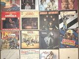 many different album covers on the wall of a room