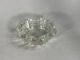 an image of a clear glass ashtray on a white surface