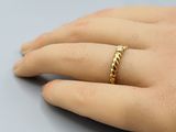 un gros plan sur la main d'une personne portant une bague en or