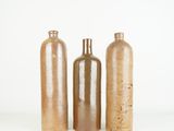 three bottles are lined up in a row on a white surface