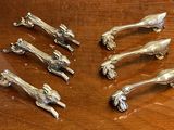six pieces of silverware sitting on a wooden table
