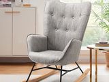 Le fauteuil à bascule gris se trouve à côté d'une table sur laquelle est posée une plante en pot.