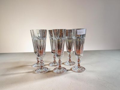 quatre verres à vin posés sur une table, sur fond blanc