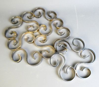 un tas d'anneaux métalliques posés sur une surface blanche