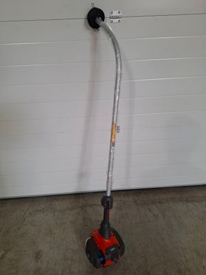 une photo d'une tondeuse à gazon rouge et noire devant une porte de garage