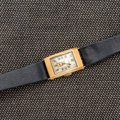 un gros plan d'une montre posée sur un morceau de tissu