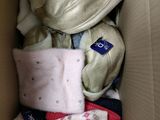 une boîte en carton remplie de vêtements et d'une peluche