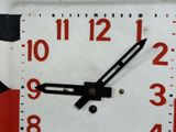 a white clock with red numbers on the face