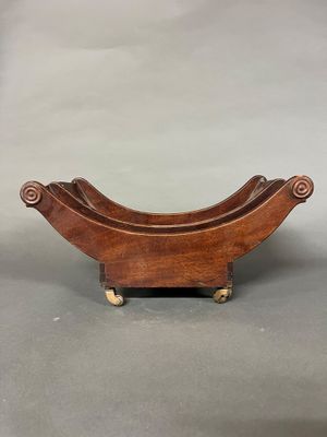 une vieille jardinière en bois munie de roulettes, posée sur une surface grise