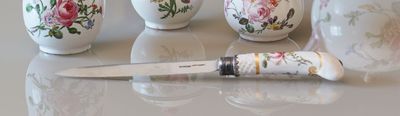 four small vases sitting next to a knife on a table