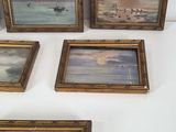 four framed paintings of boats on display on a white surface