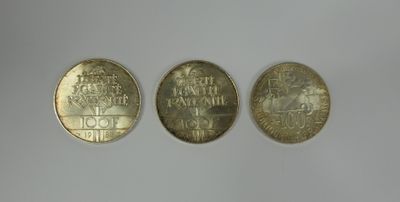 three different types of coins sitting on top of a white surface