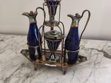 trois vases bleus et un plateau en argent posés sur une table en marbre