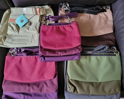 many different colored bags sitting on a couch