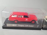 two red cars in a clear display case on a table