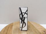 Mascara YSLF noir et blanc posé sur une table en bois