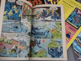 a book open on a table with comic books on it