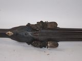a gun that is on display on a white surface