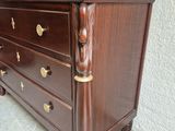 a brown dresser with gold hardware on it in a room