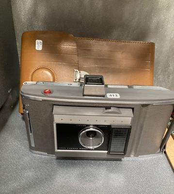 un vieil appareil photo posé sur un étui marron