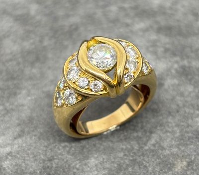 an image of a gold ring with diamonds on a gray surface