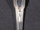 a silver spoon with a spoon handle on a black surface