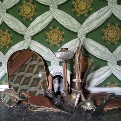 une photo représentant une table avec un miroir, un miroir, une paire de chaussures et une paire de ciseaux