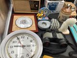 a table with a clock, a radio, a camera, and other items on it
