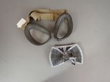 two pairs of goggles and a belt on a table