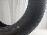 a close up of a tire on a white surface with a white curtain behind it