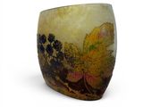 a vase with a leaf design on it on a white surface