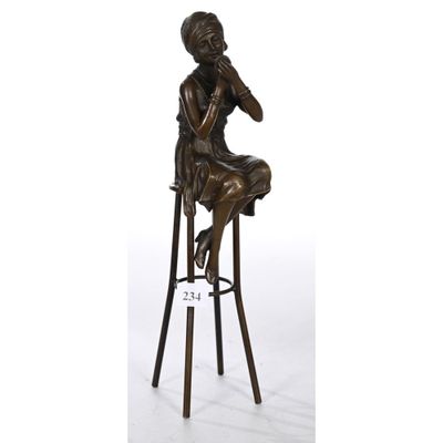 une statue en bronze représentant une femme assise sur un tabouret