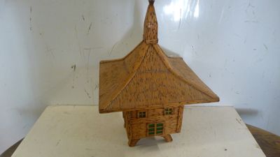 une petite maison en bois posée sur une table