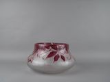 a glass vase with a red and white design on it