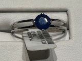 une bague sertie d'une pierre bleue, dans un écrin