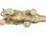a gold statue of an elephant laying down on its back
