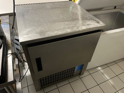 a silver refrigerator sitting in a kitchen next to a stove