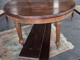 a wooden table with a bench on it in the middle of a room