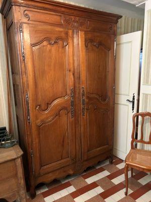 une armoire en bois dans une pièce au sol en damier