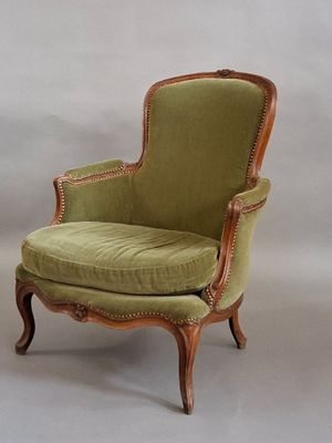 a chair with a green upholstered seat and a wooden frame
