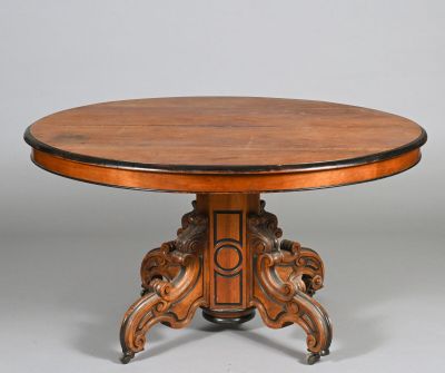 a round table with a wooden top and carved legs