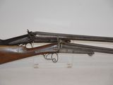 two old guns are on display on a white surface