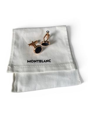 un gros plan sur une paire de boutons de manchette posés sur un tissu blanc
