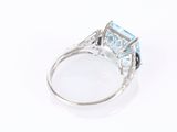 an image of a ring with a blue topaz stone and diamonds