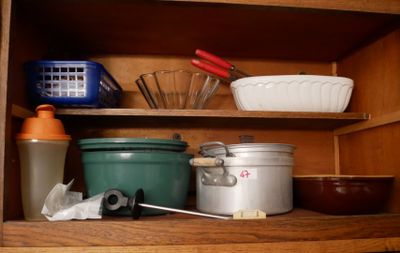 une étagère en bois sur laquelle sont posés divers ustensiles de cuisine