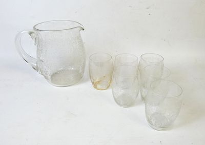 quatre verres et un pichet posés sur une table