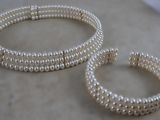 deux bracelets en perles et une bague posés sur une surface en marbre