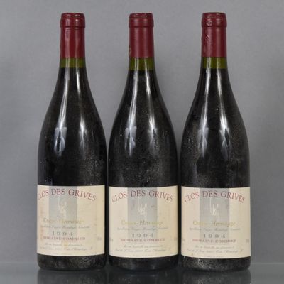 three bottles of red wine are lined up on a table