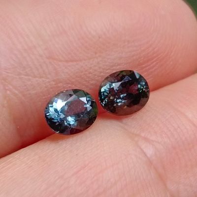 deux diamants bleus et violets posés sur le doigt d'une personne